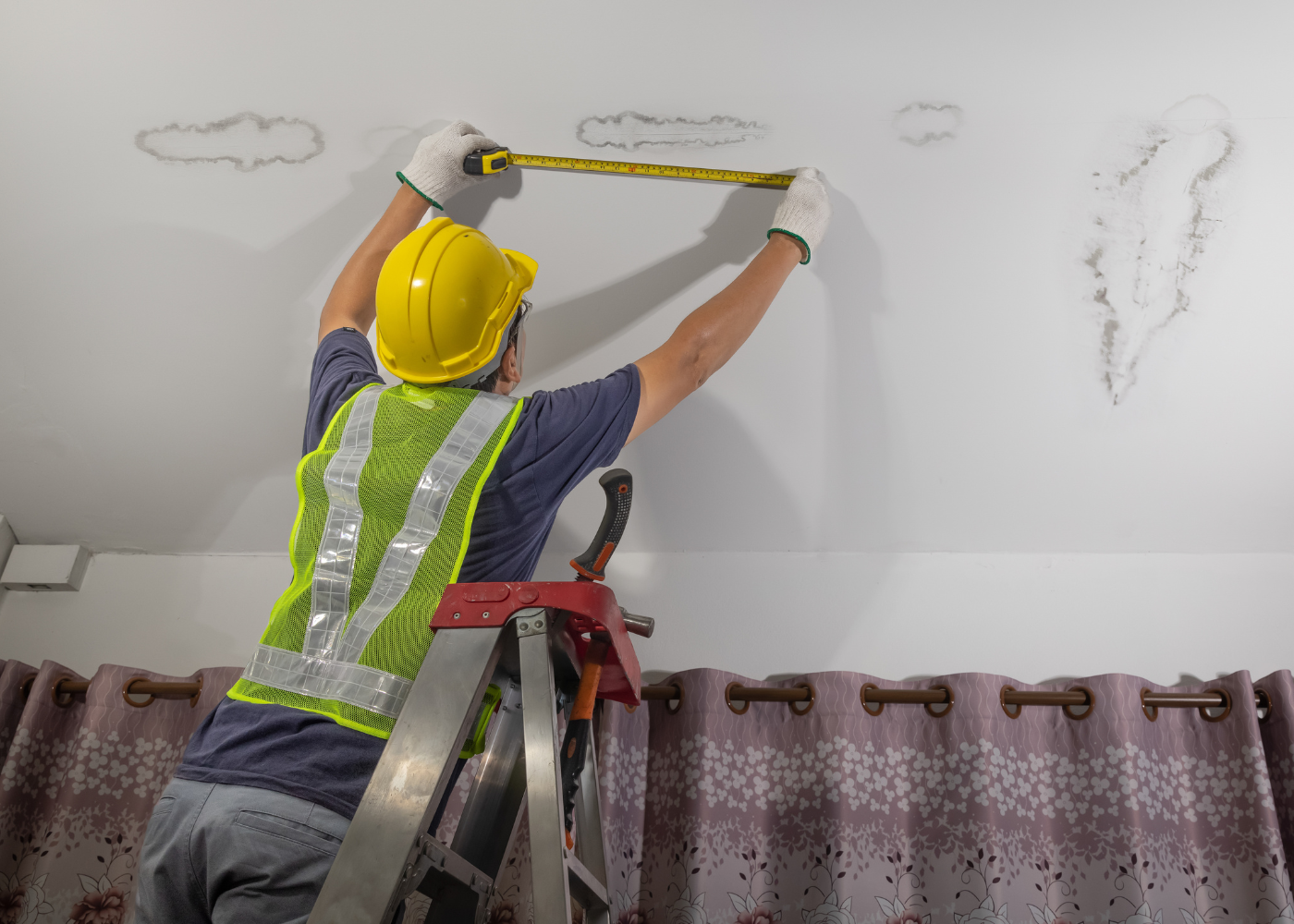 professional painter in the process of analyzing ceiling for damage