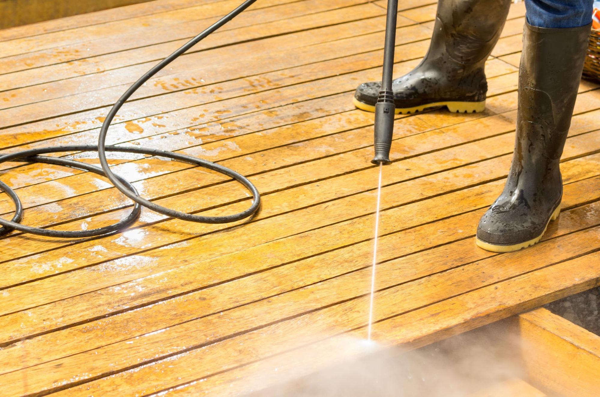 an image of somebody powerwashing a deck
