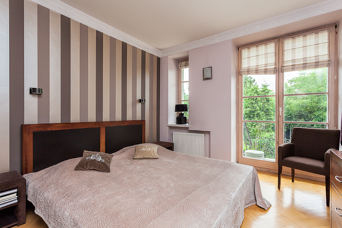 Bedroom decorated in warm, brown tones, with a vertical geometric wall pattern.